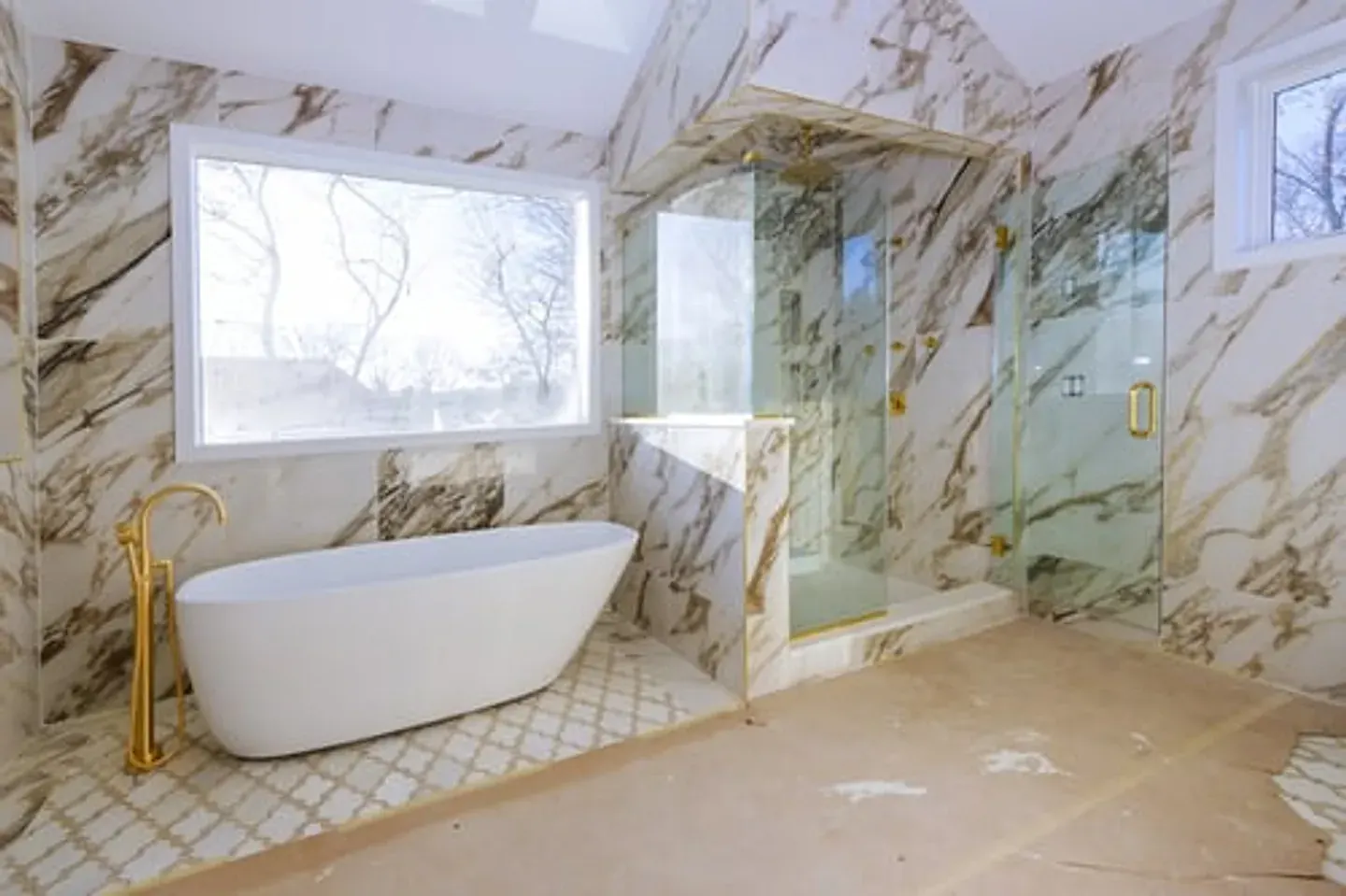 Renovated marble bathroom with freestanding tub and glass shower