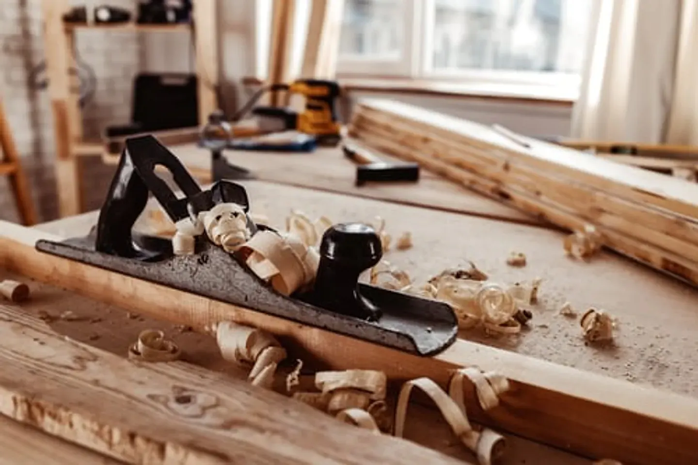 Hand plane and wood shavings on a carpentry workbench