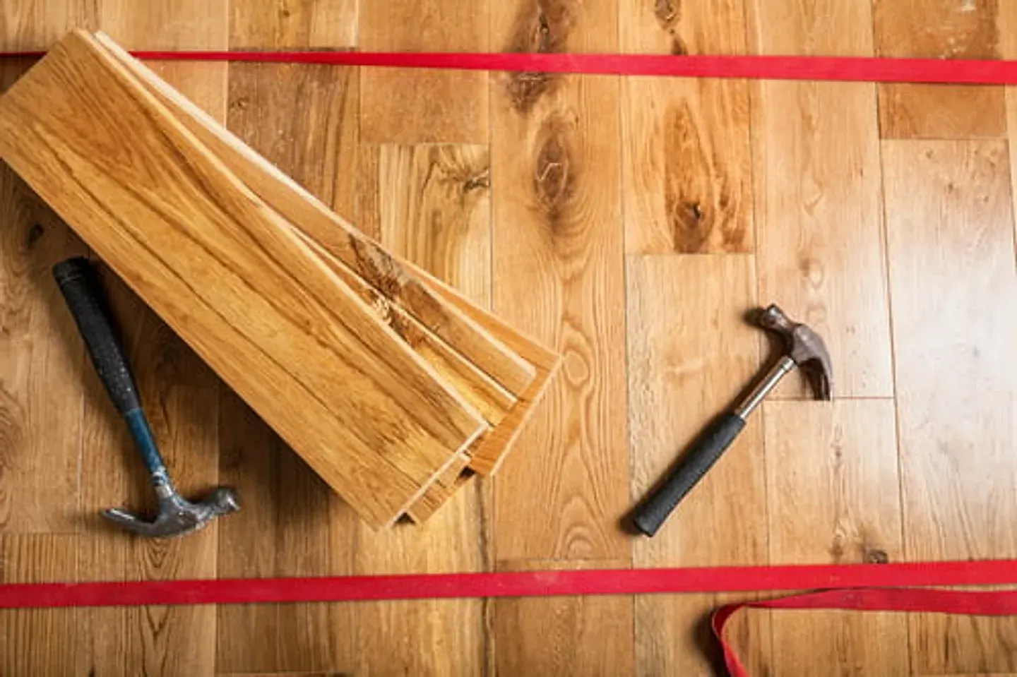 Hardwood flooring planks and tools laid out for installation